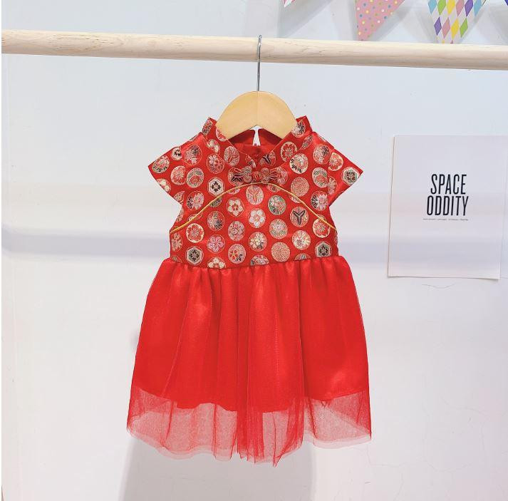 alt text: Bé gái mặc váy gấm đỏ