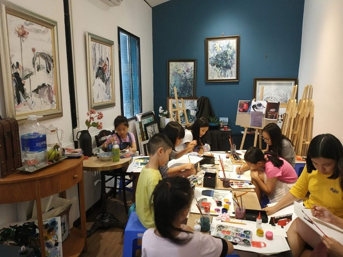 Alt text: Lớp vẽ Hoa Đồng với không gian ấm cúng, các bé đang học vẽ cùng giáo viên.